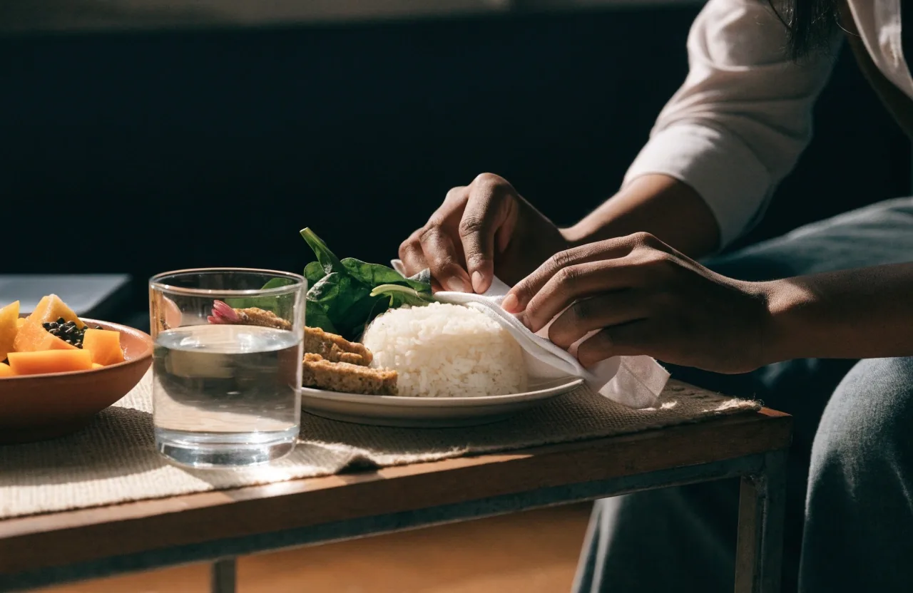 A woven mat and a set table for two photographed through a warm doorway